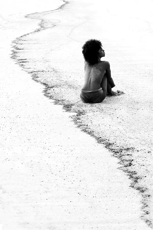 Campagne mode éditoriale, mannequin capturé avec un contraste saisissant en noir et blanc, pose et paysage doux et harmonieux.